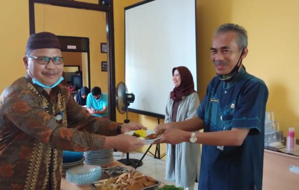 Kepala DKPUS Babel Dr Asyraf Suryadin menerima potongan nasi tumpeng pertama dari Mulyadi, Sekretaris DKPUS Babel yang akan Purna Tugas.