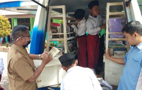 Kepsek MIN Beruas turut serta membaca koleksi buku di layanan Pusling DKPUS Babel, Selasa (24/11/2020)..