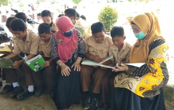 Kepala SDN 11 Air Gegas bersama Pustakawan Madya DKPUS Babel turut mendampingi Siswa SDN 11 Air Gegas membaca buku-buku yang ada di Pusling DKPUS Babel.
