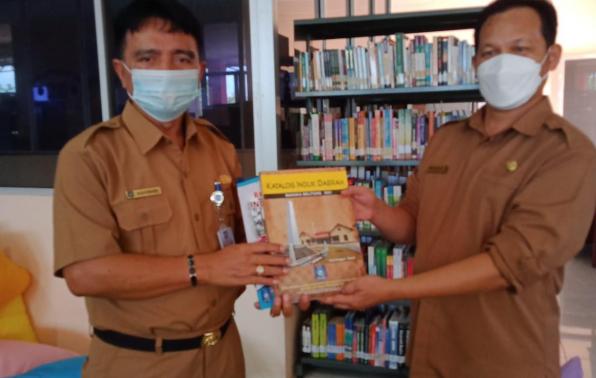 Kepala DKPUS Babel Rakhmadi menyerahkan Induk Daerah dan Katalok Induk Daerah Provinsi Babel kepada Kepala DPK Beltim Amirudin, Selasa (12/10/2021).