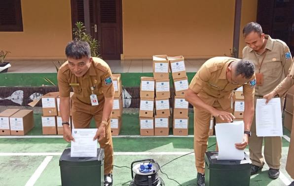 Kepala DKPUS Babel Rakhmadi bersama Sekdis DKPUS Yopi Wijaya memusnahkan simbolis arsip negara internal DKPUS Babel menggunakan mesin pencacah, Selasa (13/12/2022). 