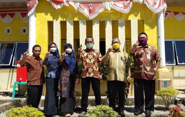 Tim Juri Lomba dari DKPUS Babel foto bersama Kades Kimak di depan Kantor Kades Kimak, Kamis (3/6/2021).
