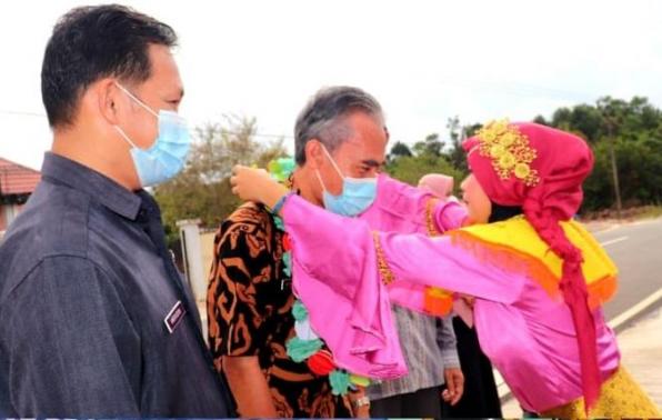Kepala DKPUS Babel Asyraf Suryadin disambut kalungan bunga saat tiba di Perpusdes Cendil, Kelapa Kampit, Beltim, Jumat (28/5/2021).