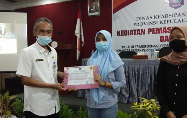 Kepala DKPUS Babel Dr Asyraf Suryadin menyerahkan Piagam Penghargaan kepada Pengunjung Perpustakaan Provinsi Babel.