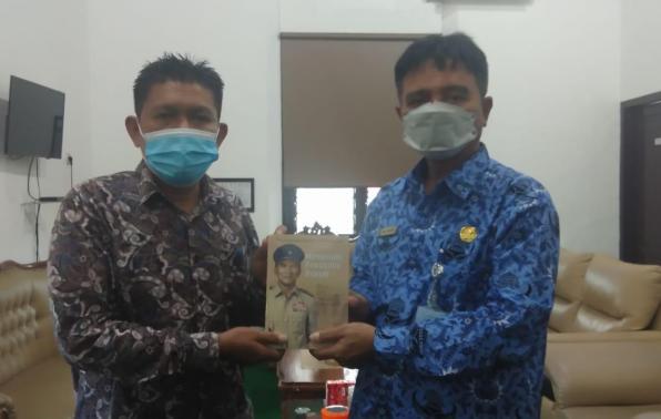 Kepala DKPUS Babel Rakhmadi menerima Buku “Kiprah dan Kenangan Sosok Hanandjoeddin” dari Haril selaku Penulis.