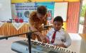 Kepala DKPUS Babel Rakhmadi saat memberikan saweran kepada Davi siswa Tuna Netra SLBN Tanjungpandan yang memiliki bakat bernyanyi dan bermain piano, Senin (11/12/2023).. 