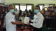 Kepala DKPUS Babel menyerahkan buku hasil karya pribadinya kepada Kepala SMAN 1 Puding Besar.