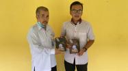 Kabid Pembinaan dan Pengembangan Perpustakaan DKPUS Babel Abu Hapas mewakili Kadis DKPUS Babel Rakhmadi menerima buku BARATA dari Handika selaku Penulis.