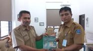 Samsul Pustakawan DKPUS Babel (kiri) menyerahkan buku ke Kepala DKPUS Provinsi Babel Rakhmadi, Selasa (22/3/2022).
